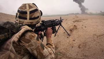 KAJAKI, AFGHANISTAN - MARCH 18: British commando Lee Oliver fires at Taliban only 400 meters away as a plume of smoke rises from an airstrike during a sunrise attack on Taliban positions on March 18, 2007 near Kajaki in the Afghan province of Helmand. Members of the 42 Royal Marines attacked a Taliban held village on the outskirts of Kajaki in an operation to push Taliban insurgents further back from a British camp at the Kajaki Dam. Operation Achilles involves some 4,500 NATO troops and is meant to secure more area near the US-Built dam so it can be upgraded and its electrical output expanded. (Photo by John Moore/Getty Images) GUERRA