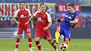 Freiburg's German midfielder Lino Tempelmann (C) and Leipzig's Austrian midfielder Marcel Sabitzer (R) vie for the ball during the German first division Bundesliga football match between RB Leipzig and SC Freiburg in the Red Bull arena in Leipzi
