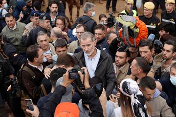  El rey Felipe VI habla con vecinos afectados por la riada, durante su visita a Paiporta este domingo. 