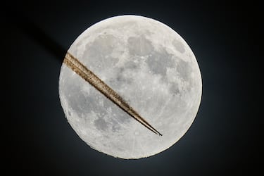 Un avión pasa cerca de la luna sobre Frankfurt, Alemania.