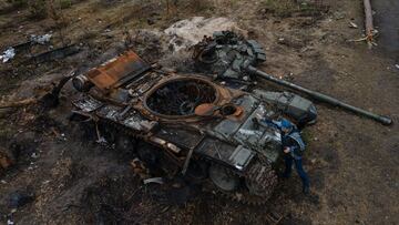 DMYTRIVKA, UKRAINE - APRIL 21: In this aerial image, a man places a boot to take a photo of a destroyed Russian military tank on April 21, 2022 in Dmytrivka, Ukraine. (Photo by Alexey Furman/Getty Images)