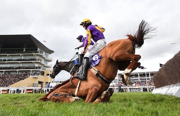 El caballo Copperhead montado por Harry Cobden y el caballo Easy Game del jinete Danny Mullins, caen al suelo durante la RSA Insurance Novices' Chase en Cheltenham, Inglaterra.