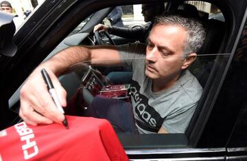 Mourinho signs a Manchester United jersey in London.