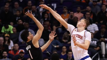 Devin Booker lanza a canasta ante Kristaps Porzingis.