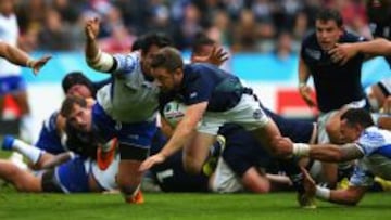 Greig Laidlaw, de escocia, esquiva a la defensa de Samoa.