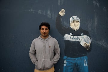 Mural de Diego Armando Maradona en el estadio Juan Carmelo Zerillo del Club de Gimnasia y Esgrima La Plata en  Buenos Aires, Argentina. En la imagen posa Leonardo Sánchez, trabajor de club, junto a la pintura.