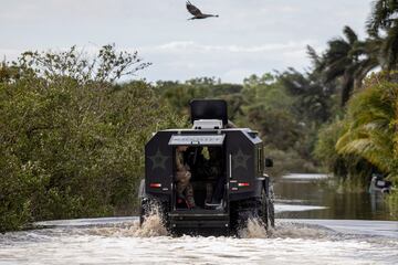 Autoridades del condado de Lee viajan en un vehículo para buscar a los residentes varados en las comunidades inundadas en Iona, Florida.