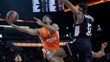 VALENCIA, 20/01/2026.- El escolta del Valencia Basket Kameron Taylor (c) entra a canasta junto a Allan Dokossi (d), del París Baketball, durante el partido de baloncesto correspondiente a la J23 de la EuroLiga que Valencia Basket y París Baketball disputan hoy martes en el Roig Arena de Valencia. EFE/Miguel Ángel Polo.