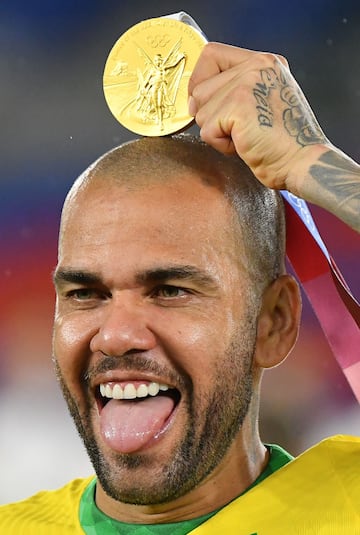 El futbolista Dani Alves celebra así la medalla de oro ganada con Brasil.  