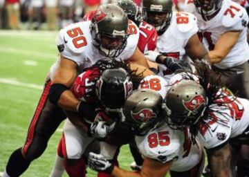 Jacquizz Rodgers de los Atlanta Falcons protege el balón ante los jugadores de los Tampa Bay Buccaneers.