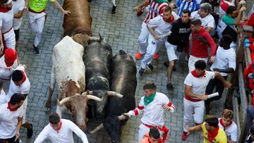 Revellers sprint in front of bulls during the running of the bulls at the San Fermin festival in Pamplona, Spain, July 10, 2022. REUTERS/Juan Medina