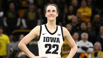 IOWA CITY, IOWA- FEBRUARY 15: Guard Caitlin Clark #22 of the Iowa Hawkeyes listens as the crowd cheers after breaking the NCAA women's all-time scoring record during the game against the Michigan Wolverines at Carver-Hawkeye Arena on February 15, 2024 in Iowa City, Iowa.   Matthew Holst/Getty Images/AFP (Photo by Matthew Holst / GETTY IMAGES NORTH AMERICA / Getty Images via AFP)