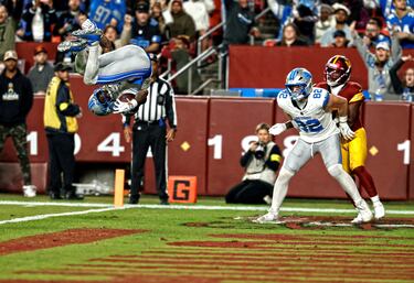 El receptor abierto de los Detroit Lions, Jameson Williams, realiza una espectacular voltereta en el aire para celebrar la anotación de un touchdown en el tercer cuarto del partido contra los Washington Commanders, en el Northwest Stadium. Con su destacada actuación, Williams contribuyó al triunfo de su equipo ante los Commanders por 44-22. 