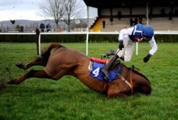 El jinete Brendan Powell se cae del caballo Flaming Charmer durante una carrera en el hipódromo de Wincanton, Inglaterra.