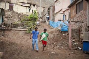 Los niños salen de sus casas para asistir a clases de surf en una playa cerca de Alto Perú chabolas de Lima. Desde 2008, la ONG Alto Perú busca ofrecer a los niños de un barrio pobre de pescadores conocido como Alto Perú, la oportunidad de aprender y practicar deportes alternativos como el surf y el Muay Thai de forma gratuita.