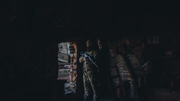 Un soldado ucraniano observa desde el interior de un edificio en su posici&oacute;n militar en un pueblo cercano a la l&iacute;nea de contacto