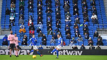 Fans, wearing a face mask or covering due to the COVID-19 pandemic, sit socially distanced during the English Premier League football match between Brighton and Hove Albion and Sheffield United at the American Express Community Stadium in Brighton, southe