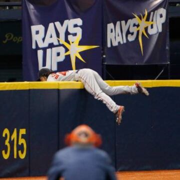 Andrew Benintendi, jugador de los Red Sox, evita el home run de Steven Souza, de los Tampa Bay Rays, lanzándose sobre el muro. 