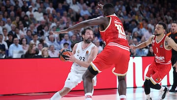Real Madrid's Spanish guard #23 Sergio Llull (L) tries to pass the ball as Olympiacos Piraeus' French center #10 Moustapha Fall defends during the Euroleague basketball quarterfinal match between Real Madrid Baloncesto and Olympiacos Piraeus at the Movistar Arena in Madrid on April 29, 2025. (Photo by Thomas COEX / AFP)