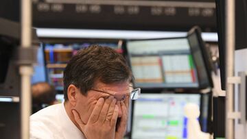 09 March 2020, Hessen, Frankfurt/Main: A stock trader rubs his eyes on the floor of the Frankfurt Stock Exchange. Stock exchanges around the world are reacting with huge losses to the fall in oil prices and concerns about the economic consequences of the 