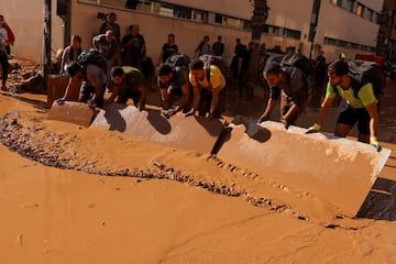 La gente retira el barro tras las fuertes lluvias que provocaron las inundaciones, en Paiporta, cerca de Valencia.