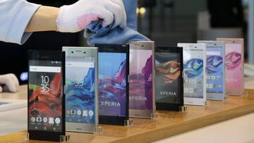 Un trabajador limpia unos m&oacute;viles Xperia de la compa&ntilde;&iacute;a Sony expuestos en su sede en Tokio (Jap&oacute;n).