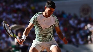 Spain's Carlos Alcaraz Garfia tries to return the ball between his leg to Italy's Lorenzo Musetti