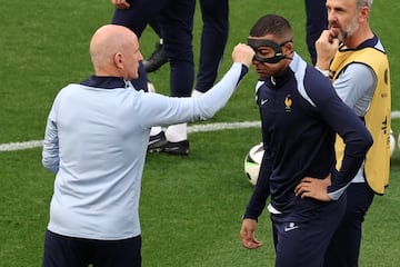 Un miembro del cuerpo técnico bromea con probar la máscara de Mbappé, durante un entrenamiento.