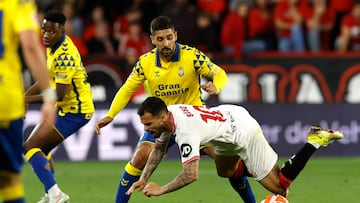 SEVILLA, 13/05/2025.- El centrocampista del Sevilla FC Suso Fernández (d) lucha con Álex Suárez, de la UD Las Palmas, durante el partido de la jornada 36 de LaLiga que Sevilla FC y UD Las Palmas disputan este martes en el estadio Ramón Sánchez-Pizjuán. EFE/Julio Muñoz