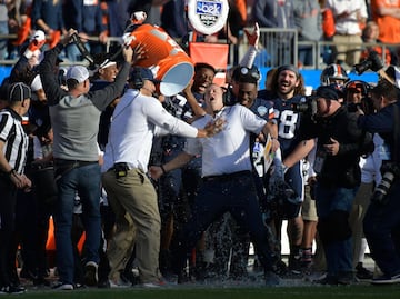 CHARLOTTE, NORTH CAROLINA - DECEMBER 29: Players douse head coach Bronco Mendenhall of the Virginia Cavaliers after a win against the South Carolina Gamecocks during the Belk Bowl at Bank of America Stadium on December 29, 2018 in Charlotte, North Carolina. Virginia won 28-0.