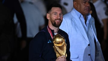 TOPSHOT - Argentina's captain and forward Lionel Messi (C) holds the FIFA World Cup Trophy upon arrival at Ezeiza International Airport after winning the Qatar 2022 World Cup tournament in Ezeiza, Buenos Aires province, Argentina on December 20, 2022. (Photo by Luis ROBAYO / AFP)