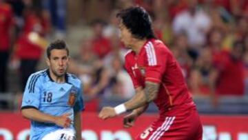 SEl defensa de la selección española, Jordi Alba, golpea el balón ante el jugador de la selección China, Zhang Linpeng.