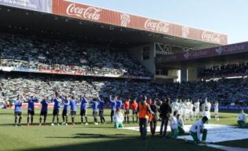 Los dos equipos saludan desde el centro del campo. 