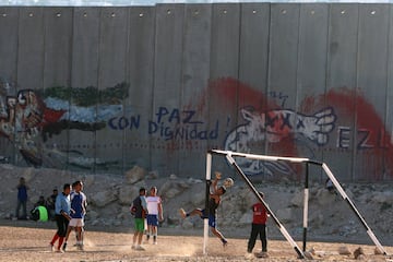 Jvenes palestinos juegan al ftbol junto a un tramo de la barrera de separacin israel, en la aldea cisjordana de Abu Dis, a las afueras de Jerusaln.