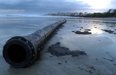 Un tramo de oleoducto cubierto de petróleo en una playa cerca del pueblo de Caión, en el norte de España. 