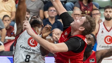 El pívot sueco de UCAM Murcia Simon Birgander hace un tapón al pívot cubano de Casademont Zaragoza Yoanki Mencía (i), durante el partido de la cuarta jornada de la liga Endesa que están disputando este sábado en el Palacio de los Deportes de Murcia.