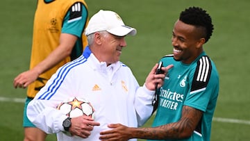 Real Madrid's Italian coach Carlo Ancelotti (L) jokes with Real Madrid's Brazilian defender Eder Militao during a training session at the Ciudad Real Madrid in the Madrid's suburb of Valdebebas during the club's Media Day on May 24, 2022 ahead of their UEFA Champions League final match against Liverpool. (Photo by GABRIEL BOUYS / AFP)