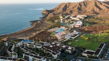 Vista a&eacute;rea del Hotel Porwered by Playitas Resort de Tuineje, Fuerteventura, con la playa y las monta&ntilde;as al fondo. 