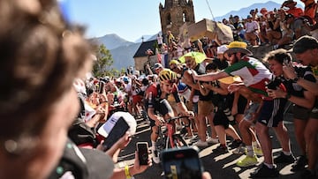 Ineos Grenadiers team's British rider Thomas Pidcock cycles past "Dutch corner" in the ascent of Alpe d'Huez during the 12th stage of the 109th edition of the Tour de France cycling race, 165,1 km between Briancon and L'Alpe-d'Huez, in the French Alps, on July 14, 2022. (Photo by Marco BERTORELLO / AFP)