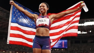 La atleta estadounidense Allyson Felix posa con la bandera de Estados Unidos tras ganar la medalla de bronce en la prueba de 400 metros en Tokio 2020.