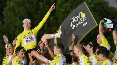 (FILES) UAE Team Emirates team's Slovenian rider Tadej Pogacar celebrates his overall victory on the podium with teammates and staff after the 21st and final stage of the 111th edition of the Tour de France cycling race, a 33,7 km individual time-trial between Monaco and Nice, on July 21, 2024. (Photo by Thomas SAMSON / AFP)