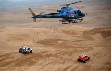 El piloto de Toyota Giniel De Villiers y su copiloto Dennis Murphy de Sudáfrica y el piloto francés Sebastien Loeb y el copiloto belga Fabian Lurquin compiten bajo la mirada del helicóptero. 