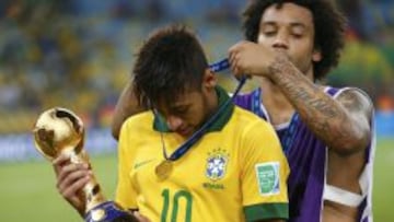 Neymar sostiene la Copa Confederaciones mientras que Marcelo le coloca la medalla a su espalda.