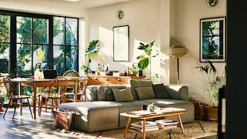 Comfortable living room with sofa and coffee table, dining table and chairs, with patio doors leading into garden