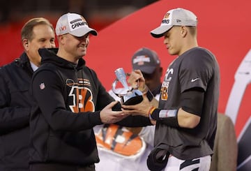 Zac Taylor y Joe Burrow sostienen el trofeo Lamar Hunt tras ganar el AFC Championship Game.