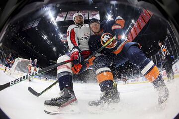 Tom Wilson, el número 43 de los Washington Capitals, lucha con Scott Mayfield, el 24 de los New York Islanders, por la posesión del puck durante el partido de la NHL que enfrentó a ambos equipos en el Nassau Coliseum, en Uniondale, Nueva York. Se impuso el equipo local, los Islanders, por 1-0. Anotó Brock Nelson.