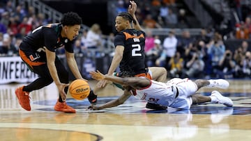 KANSAS CITY, MISSOURI - MARCH 24: Tramon Mark #12 of the Houston Cougars dives for the ball against Isaiah Wong #2 and Nijel Pack #24 of the Miami Hurricanes during the first half in the Sweet 16 round of the NCAA Men's Basketball Tournament at T-Mobile Center on March 24, 2023 in Kansas City, Missouri. Jamie Squire/Getty Images/AFP (Photo by JAMIE SQUIRE / GETTY IMAGES NORTH AMERICA / Getty Images via AFP)