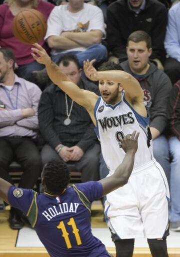 Ricky Rubio lanza hacia la canasta ante la marca de Jrue Holiday.