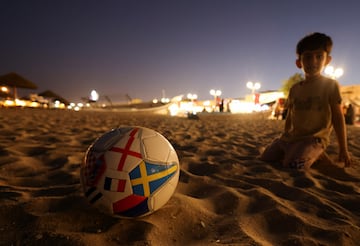 A boy plays with a football decorated with flags, ahead of 2022 FIFA World Cup soccer tournament, in Al Wakrah, south of Doha, Qatar, November 10, 2022. REUTERS/Amr Abdallah Dalsh