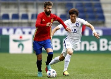 Gerard Pique y Hwang Ui-jo.